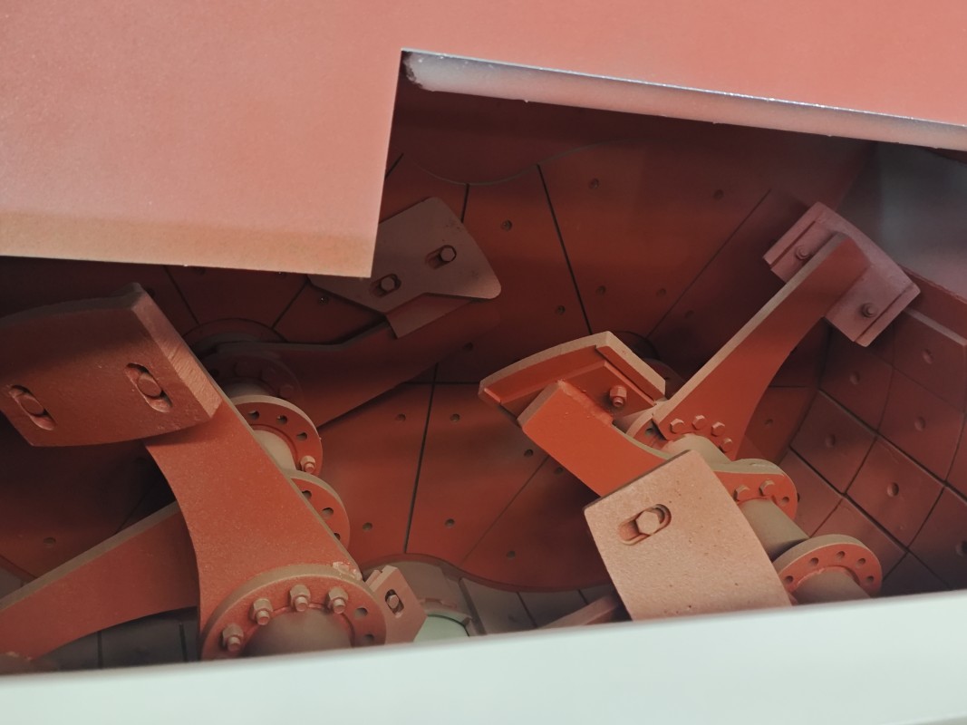 Interior wear liners and mixing arms inside a concrete mixer